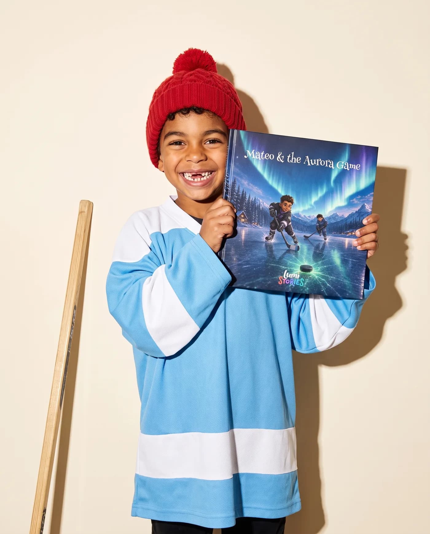 A boy in a hockey jersey and toque holds up his own copy, Mateo and the Aurora Game, with his illustrated hero on the cover