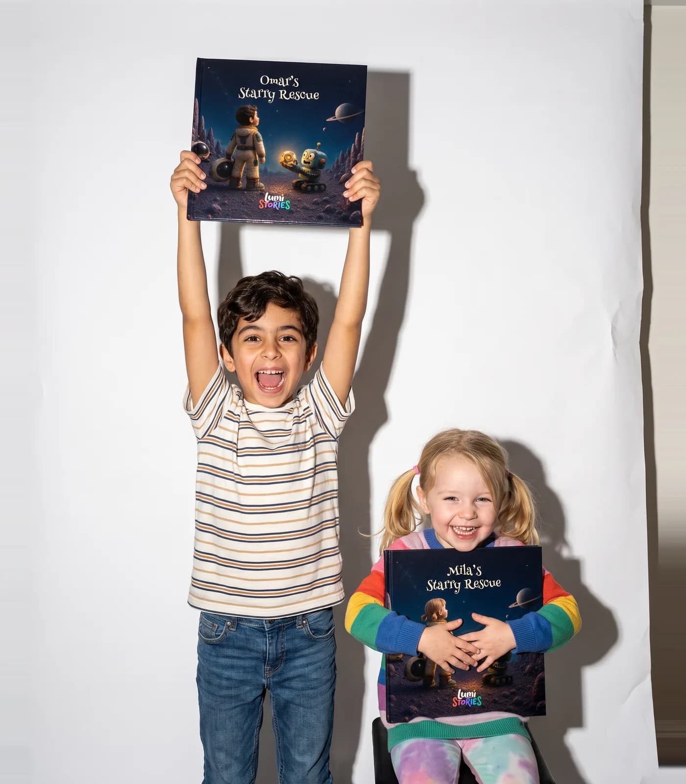 Two siblings on a white studio backdrop, each holding their own copy